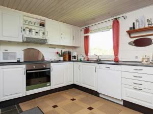 a white kitchen with white cabinets and a window at 6 person holiday home in Farsø-By Traum in Farsø +13 photos