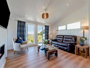 a living room with a leather couch and a table at 1 Bed in Langbank 95823 in Langbank