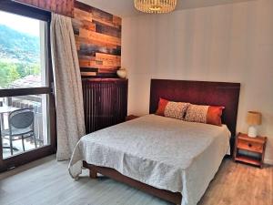 a bedroom with a bed and a large window at Appartement lumineux au ski pour 6 - Grand balcon, cœur du village - FR-1-458-96 in Le Grand-Bornand +8 photos