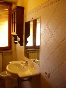 マリーナ・ディ・グロッセートにあるAppartamento Il Soleのバスルーム(洗面台、鏡付)