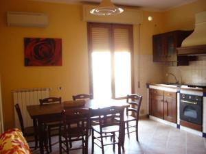 マリーナ・ディ・グロッセートにあるAppartamento Il Soleのキッチン、ダイニングルーム(テーブル、椅子付)