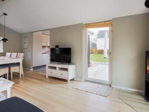 a living room with a television on a white cabinet at 6 person holiday home in Væggerløse in Bøtø By +34 photos