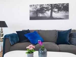 a living room with a couch and a table with flowers at 4 person holiday home in Ebeltoft in Ebeltoft +14 photos