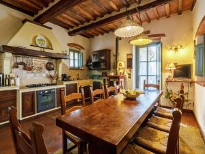 a large kitchen with a wooden table and chairs at Luxury pool villa in Cortona in Cortona