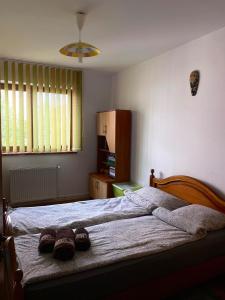 a bedroom with a bed with two slippers on it at Lovely entire apartment in Cugir in Cugir