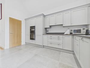 une cuisine blanche avec des armoires et des appareils blancs dans l'établissement Oakwood Lodge, à Matlock