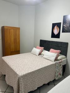 una camera da letto con un letto con cuscini rosa di Casa do umbuzeiro a Bom Jesus da Lapa