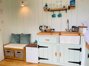 a small kitchen with white cabinets and a sink at Sea Spray in St Austell
