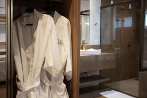 a robe hanging in a closet in a bathroom at Ellus Hotel in Dourados