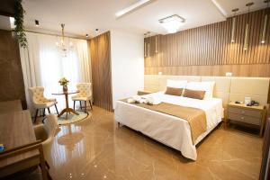 a bedroom with a large bed and a table and chairs at Ellus Hotel in Dourados