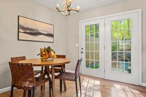een eetkamer met een tafel, stoelen en een kroonluchter bij Comfortable Stay Private Hot tub W Arcade in Sevierville