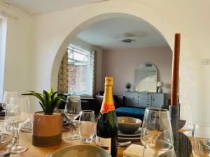 a bottle of wine sitting on a table with glasses at Large villa opposite beach in Great Yarnouth in Great Yarmouth +14 photos