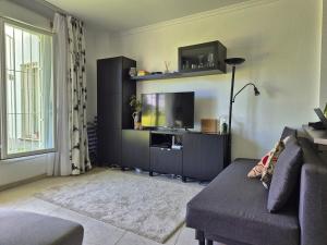 a living room with a couch and a flat screen tv at Apartment beachside in Calahonda in Cabopino