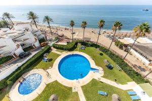 an aerial view of a swimming pool and the beach at Apartment beachside in Calahonda in Cabopino