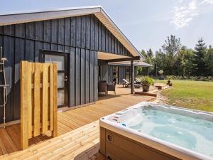 Un jacuzzi en una terraza junto a una casa. en 8 person holiday home in Væggerløse, en Bøtø By