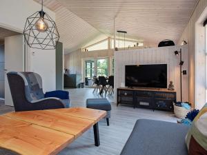 una sala de estar con un televisor y una mesa en 8 person holiday home in Væggerløse, en Bøtø By
