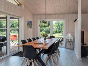 Un comedor con mesa y sillas de madera. en 8 person holiday home in Væggerløse, en Bøtø By