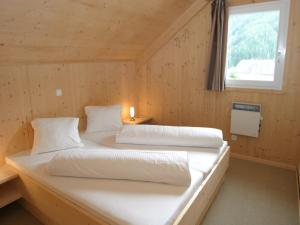 two beds in a wooden room with a window at Chalet Hohentauern am Skilift in Hohentauern