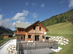a small wooden house in a field with a hill at Chalet Hohentauern am Skilift in Hohentauern