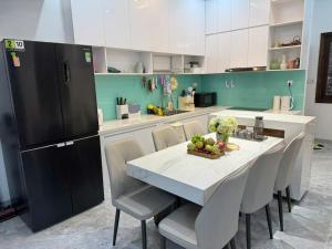 a kitchen with a table and chairs in a kitchen at CLOVER Homestay Phú Yên in Phường Sáu