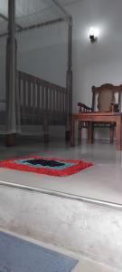 a rug on the floor in a room with a bench at T & U Homestay in Katunayaka
