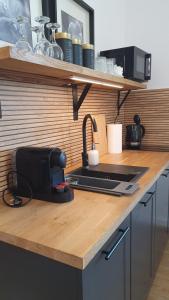 a kitchen counter with a sink and a microwave at Apartament Wieżyczka in Świdnica