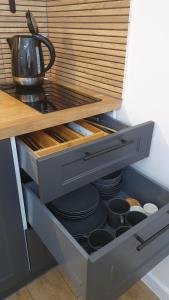 a drawer in a kitchen with plates and pans at Apartament Wieżyczka in Świdnica