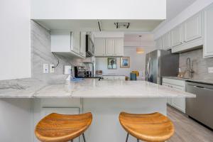 a kitchen with a large counter with two wooden stools at Phoenix II 2151 condo in Romar Beach