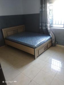 a bed sitting in a room with a window at Easybel Consult Properties in Mowe