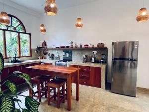 a kitchen with a wooden table and a refrigerator at La Sirena Villa in Unawatuna