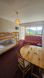 una camera con tavolo, letto e divano di Le Nid des Cimes- séjour détente face aux sommets a Laveissière