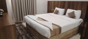 a bedroom with a large bed with white sheets and pillows at شقق الاندلس in Medina +26 photos