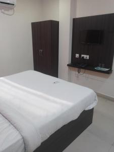 a bedroom with a bed and a tv in a room at Hotel Airport Shine Inn in Hyderabad