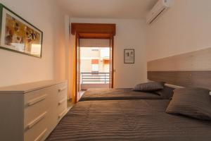 ミントゥルノにあるElisa a mareのベッドルーム1室(ベッド2台、ドレッサー付)