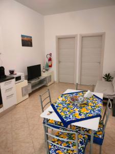 a living room with a table and a kitchen at Casa di Vicio in Marsala