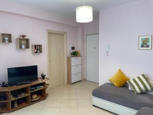 a living room with a bed and a television at Marvi's Gated Beach area apt in Durrës