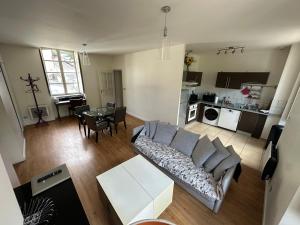 a living room with a couch and a table at Charmant appartement RDC familial ou pour le travail in Uzerche