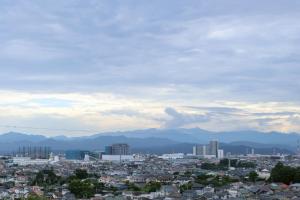 Una vista de una ciudad con montañas al fondo. en ｄｐ小山町, en Machida