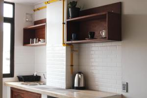 a kitchen with wooden cabinets and a counter top at Kunan Hotel in Cochabamba