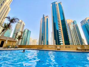 a swimming pool in a city with tall buildings at JBR Skyview Rooms in Dubai