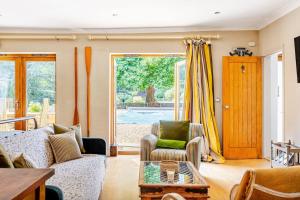 a living room with a couch and a table at The Old Pool House, Stylish Large Studio in Private Country Estate with Air Con in Bradford on Avon