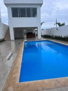 a large blue swimming pool in front of a house at Apartment near the airport in Boca Chica