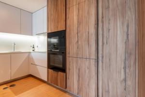ヴィラ・ノヴァ・デ・ガイアにあるPremium Apartment w/ Garage & Balcony by HostWiseの木製の壁のキッチン(電子レンジ付)