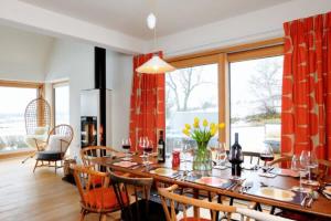 una sala da pranzo con tavolo lungo e sedie di Beautiful Lodge with hot tub & panoramic views a Boat of Garten