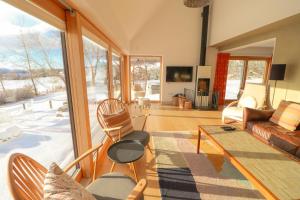 un soggiorno con un divano e un tavolo di Beautiful Lodge with hot tub & panoramic views a Boat of Garten