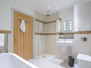 un bagno con wc, lavandino e doccia di Beautiful Lodge with hot tub & panoramic views a Boat of Garten Altre 33 foto