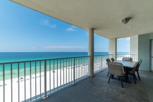 un balcon avec une table et des chaises et l'océan dans l'établissement Long Beach T4-1004 'Emerald Retreat', à Panama City Beach