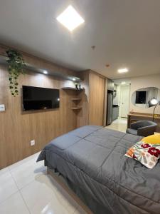 a bedroom with a bed and a flat screen tv at Studio novo e completo, Jardim Amália in Volta Redonda