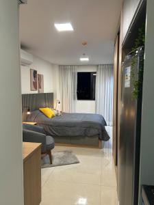 a bedroom with a bed and a couch in a room at Studio novo e completo, Jardim Amália in Volta Redonda