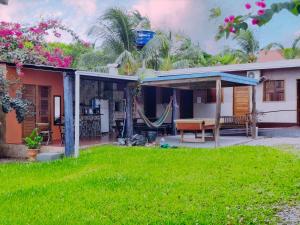 a house with a hammock in the yard at Casa Com bilhar 4 quartos alter in Alter do Chao